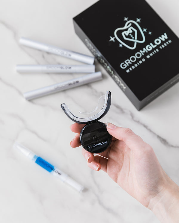 GroomGlow black whitening kit box with gel pens and LED mouthpiece on marble