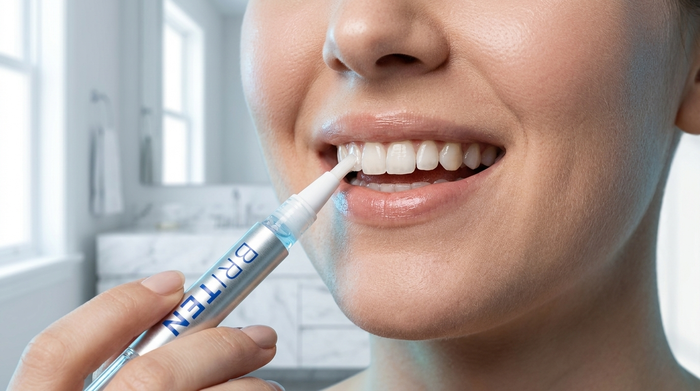 Person applying BRITEN whitening gel pen to their teeth